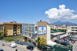 a building with cars parked in a parking lot at Apartments Mirosa in Pompei