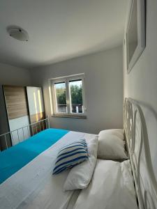 sypialnia z dużym białym łóżkiem z niebieską pościelą w obiekcie Apartman Kačić w mieście Sveti Ivan Dobrinjski