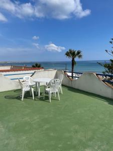 einen Tisch und Stühle auf einer Terrasse mit Strand in der Unterkunft Villa del Nonno in Mazara del Vallo