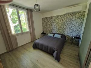 a bedroom with a large bed and a window at Bienvenue chez José et Hélène maison de village in Montfrin