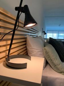 une lampe noire sur une table à côté d'un canapé dans l'établissement SP Central Loft, à Vólos