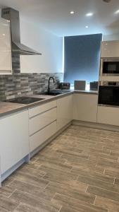 a kitchen with white cabinets and a tile floor at Church inn en-suite rooms with Wi-Fi in Moorside