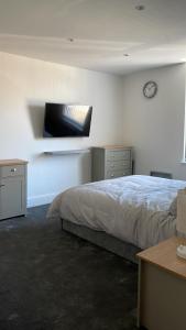 1 dormitorio con 1 cama y reloj en la pared en Church inn en-suite rooms with Wi-Fi, en Moorside
