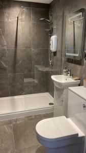 uma casa de banho com um chuveiro, um WC e um lavatório. em Church inn en-suite rooms with Wi-Fi em Moorside