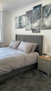 um quarto com uma cama com quatro fotografias na parede em Church inn en-suite rooms with Wi-Fi em Moorside
