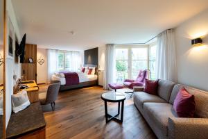 a living room with a couch and a bed at Hotel Zum Ochsen in Schonwald im Schwarzwald