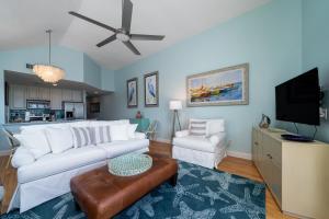 a living room with a white couch and a tv at 13108 Pelican Watch Villa in Seabrook Island