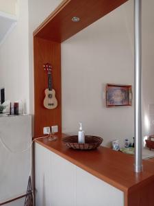 eine Küche mit einer Theke mit einer Gitarre an der Wand in der Unterkunft Ukulele central apartment in Sami