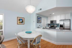 a white kitchen with a white table and chairs at 13108 Pelican Watch Villa in Seabrook Island