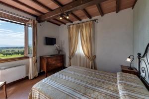 a bedroom with a bed and a large window at Locanda Poggioleone in Castiglione del Lago
