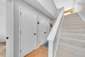 a stairway with white walls and stairs with a white door at 1235 Creekwatch Villa in Seabrook Island