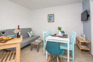 a living room with a couch and a table with chairs at Apartmani Podoreški in Vir