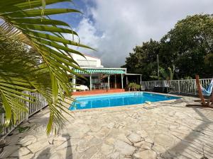 a swimming pool in front of a house at Notre Vie Là in Le Robert
