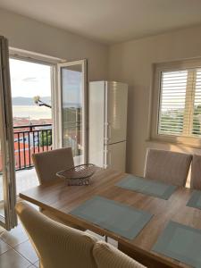 a dining room with a table and a refrigerator at Apartments Lili in Senj