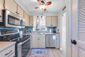 a kitchen with white cabinets and a ceiling fan at 1235 Creekwatch Villa in Seabrook Island