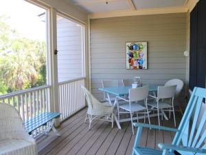 - une terrasse couverte avec une table et des chaises bleues dans l'établissement 3002 Salt Marsh, à Seabrook Island