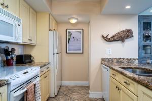 a kitchen with a white refrigerator and a sink at 1385 Pelican Watch Villa in Seabrook Island +29 photos