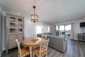 a living room with a table and a couch at 1385 Pelican Watch Villa in Seabrook Island