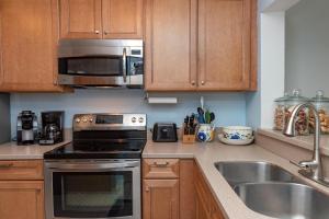 a kitchen with a stove and a sink and a microwave at 1211 Creekwatch Villa in Seabrook Island