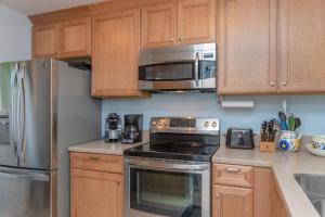 a kitchen with a stainless steel refrigerator and a microwave at 1211 Creekwatch Villa in Seabrook Island +34 photos