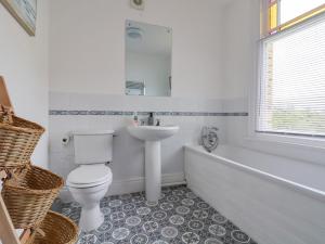 a bathroom with a toilet and a sink and a tub at 18 Ffordd Tanrallt in Prestatyn
