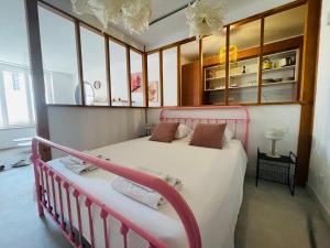 - une chambre avec un lit rose dans l'établissement Le trois nourrices, à Narbonne