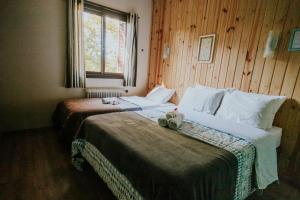 una camera d'albergo con due letti e una finestra di Pousada Casa da Paz a Gramado