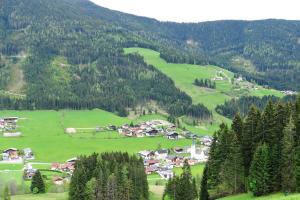 uma pequena aldeia num vale verde com árvores em Buttermilchalm em Sankt Martin am Tennengebirge