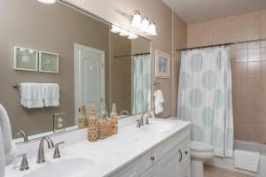 Un baño con dos lavabos, un inodoro y un espejo. en 2888 Old Drake Drive, en Seabrook Island 32 fotos más