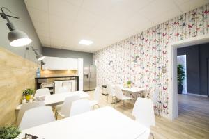a dining room with white tables and white chairs at Hostel Filip 2 in Gdańsk
