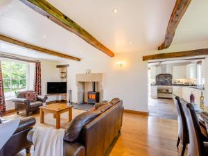 a living room with leather furniture and a fireplace at Warth House - Uk44209 in Ingleton