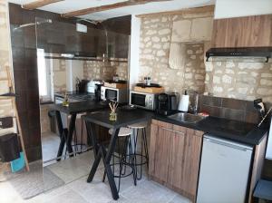 a kitchen with two tables and a counter top at L'instant Civray in Civray-sur-Esves