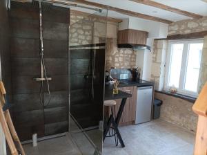 a shower with a glass door in a kitchen at L'instant Civray in Civray-sur-Esves
