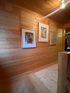 a room with wooden walls with two pictures on the wall at Frein Chalets - Kaltenbach in Frein