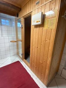 ein Badezimmer mit einer Holztür und einem roten Teppich in der Unterkunft Frein Chalets - Kaltenbach in Frein