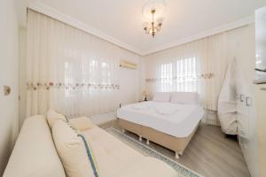 a white bedroom with a bed and a couch at Apartment with Panoramic City View in Kepez in Antalya
