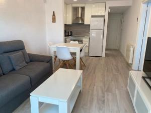 a living room with a couch and a table and a kitchen at Montiro in L'Escala +2 photos