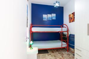 Zimmer mit 2 Etagenbetten an einer blauen Wand in der Unterkunft Casa Blu in Castellammare del Golfo