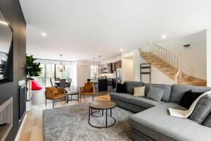 a living room with a couch and a table at Le Memph Hirondelle spacious comfortable condo cottage eco responsible 3 bedrooms - hot tub & pool Memphrémagog Lake in Magog-Orford
