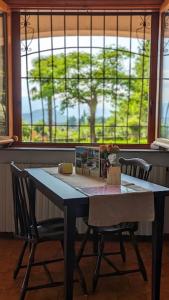 un tavolo da pranzo con due sedie e una finestra di Villa Le Arcate zona Lago Maggiore a Cittiglio