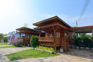 uma casa de madeira com um alpendre e uma varanda em Chomduen Phu Kao Resort em Non Sang