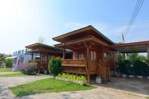 a wooden house with a porch and a balcony at Chomduen Phu Kao Resort in Non Sang