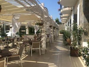 un patio al aire libre con mesas, sillas y anophe en Sea Star Sozopol en Sozopol