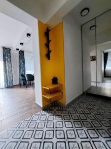 a hallway with a yellow wall and a table at Home Apartment LUNA in Skopje