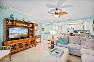 a living room with a couch and a tv at San Carlos #407 in Gulf Shores