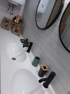 y baño con lavabo blanco y espejo. en Home Apartment LUNA, en Skopje