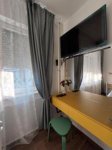 a room with a desk with a television and a green chair at Home Apartment LUNA in Skopje