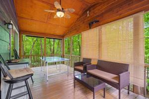 a screened porch with a table and chairs and a ceiling fan at Artisan Hideaway in Helen