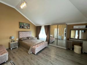 een grote slaapkamer met een bed en een televisie bij Aylin Boutique Hotel in Gabala