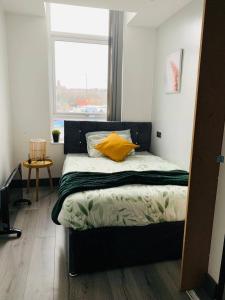 a bedroom with a bed with a yellow pillow and a window at Bohemian Chic Retreat in Liverpool